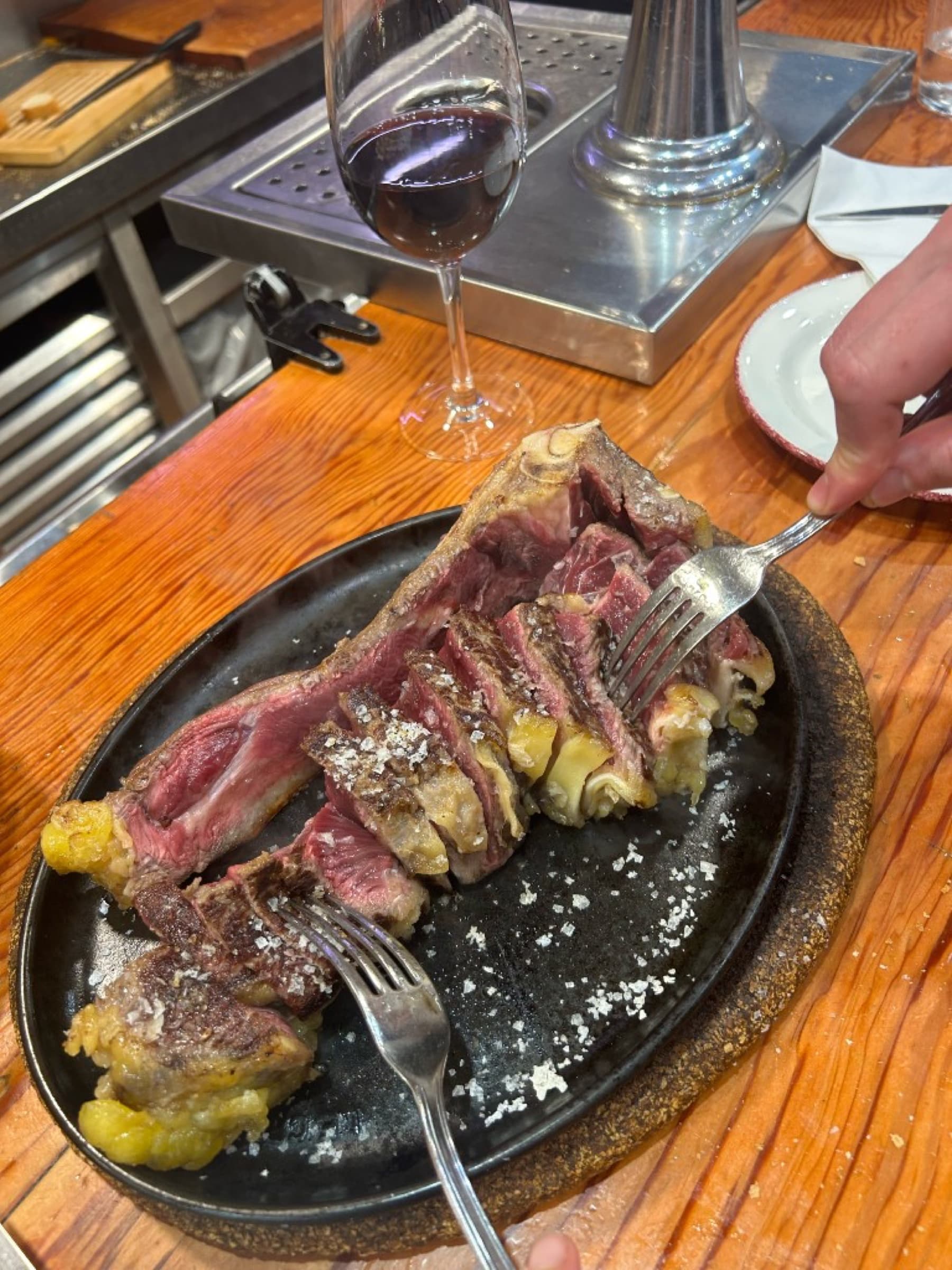 The txuleta, sliced rare on a smoking-hot cast-iron plate